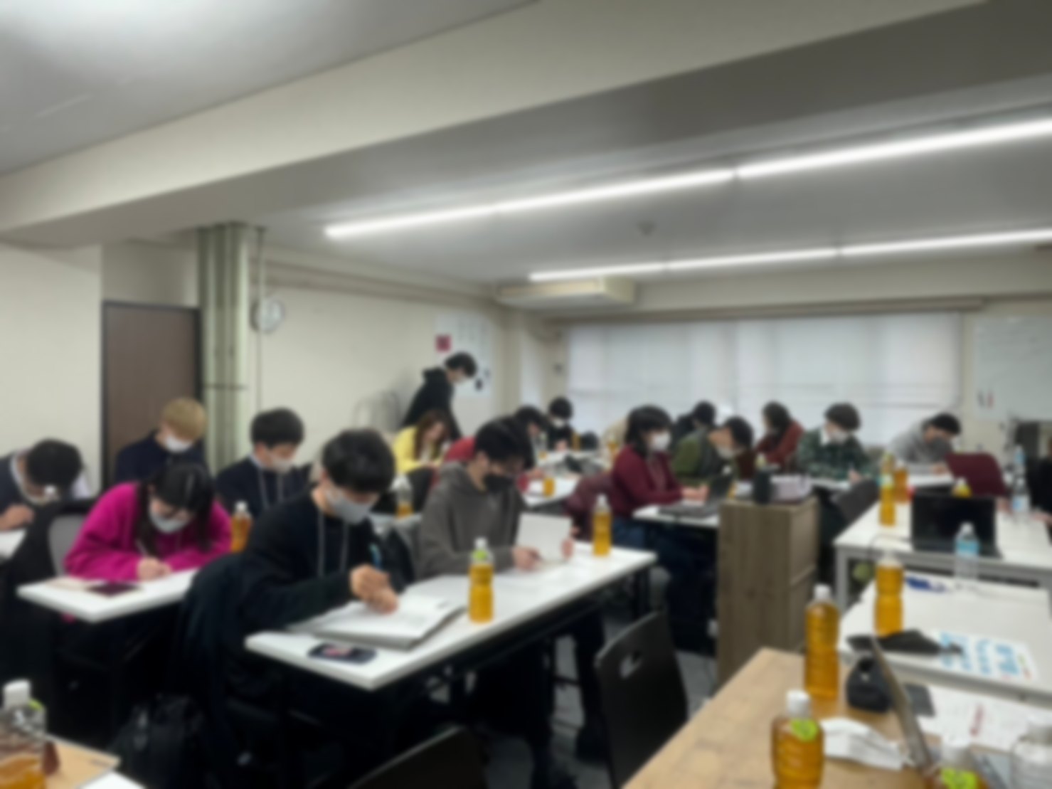 会議室に並んだ机で受講者がWebマーケティングの講義を受けている様子