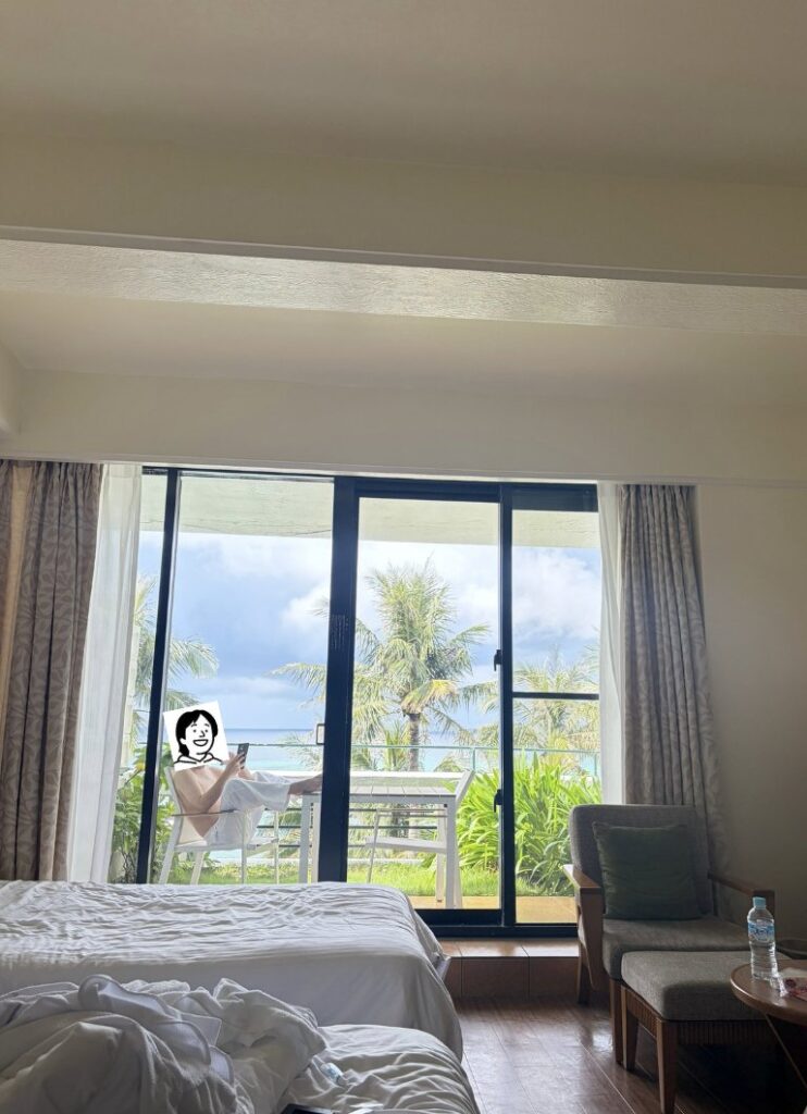 沖縄旅行で泊まったホテルの部屋と、バルコニーで電話をしている人