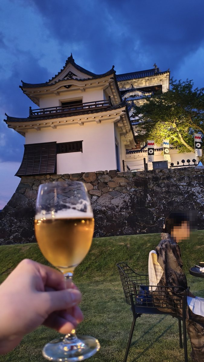 ライトアップされた大洲城を見上げる芝生の広場でビールを持っている手元